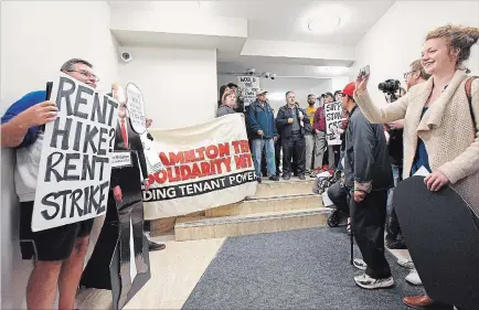  ?? JOHN RENNISON THE HAMILTON SPECTATOR ?? Rent strikers and their supporters have their photo taken in front of the wall placed over a doorway to a room off the lobby to 77 Delawana Drive where they held weekly meetings.