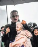  ??  ?? Actor Tom Hanks embraces Joanne Rogers, widow of the late Fred Rogers, as they sing the theme song of “Mister Rogers’ Neighborho­od” alongside a choir Friday at the rally for peace.