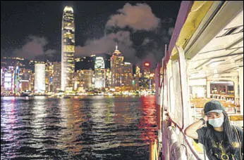  ?? AFP ?? A woman takes a ferry ride in Victoria Harbour, with Hong Kong Island seen in the backdrop.