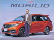  ??  ?? Mr Pitak poses with a Honda Mobilio, an innovative sub-compact MUV.