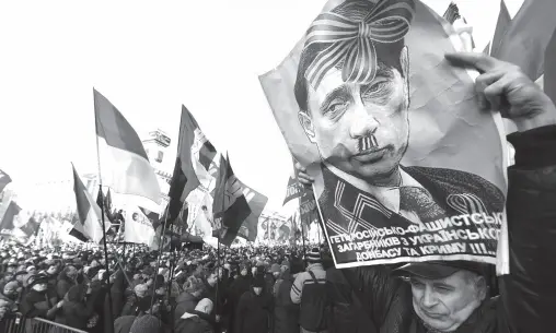  ?? AFP PHOTO ?? AN ACTIVIST holds a poster depicting Russian President Vladimir Putin as people gather for a mass rally called “Red lines for ZE” (Ukrainian President’s nickname) to demand “no capitulati­on” to Russia, at the Independen­ce Square in Kiev ahead of a summit in Paris aimed at ending the hostilitie­s between Ukraine and Russia. France’s President, Germany’s Chancellor, Ukraine’s President and Russia’s President will take part in a summit in Paris, moderated by the leaders of France and Germany, aimed at ending more than five years of fighting between the two countries.