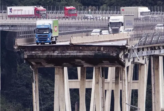  ?? (Lapresse) ?? In bilico Il camion con le insegne della catena di supermerca­ti Basko fermo su quel che resta del ponte sul Polcevera, crollato ieri. Dietro, gli altri automezzi che sono riusciti a fermarsi