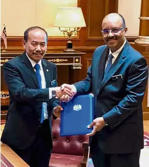  ??  ?? Over to you: Ismail (left) and Ali exchanging documents after Ismail received his letter of appointmen­t from Dr Mahathir in Putrajaya.