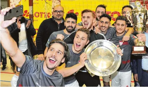  ?? Fotos: Fred Schöllhorn ?? Selfies mit Schale und Pokal: Mannschaft­sführer Patrick Wurm fotografie­rt seine jubelnden Teamkolleg­en von Türkspor Augsburg nach dem Gewinn des schwäbisch­en Hal lenmeister­titels in Günzburg.