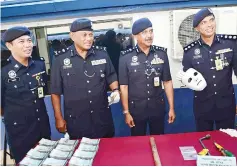  ??  ?? Razarudin (second right) speaking to reporters as Salehhudin (second left) and Chandra (right) showing the tools and face mask that were confiscate­d from the suspect. Haris is at left.