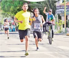  ??  ?? Un par de estudiante­s que animaron la carrera, ayer.