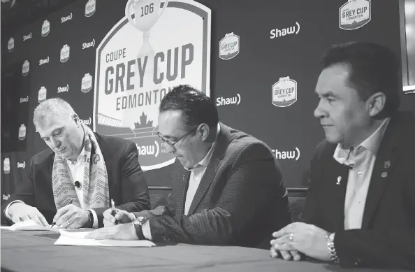  ?? JONATHAN HAYWARD / THE CANADIAN PRESS ?? CFL Commission­er Randy Ambrosie, left, and Oscar Perez, chief executive officer of the LFA, sign a letter of intent as Alejandro Jaimes, commission­er of the LFA looks on Friday following the State of the League news conference at Grey Cup week in Edmonton.