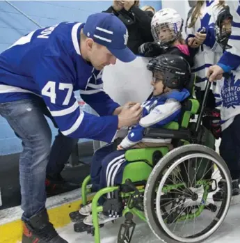  ?? LUCAS OLENIUK/TORONTO STAR ?? Leaf Leo Komorov signs the jersey of 10-year-old Justin Di Nino at Sunday’s 40th annual Easter Seals skate. The event has raised more than $6.7 million over the years for kids with physical disabiliti­es.