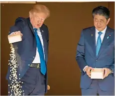  ?? FOTO: HARNIK/DPA ?? In Japan: US-Präsident Donald Trump (l) füttert edle Koi-Karpfen mit Premier Shinzo Abe – und stellt viele Gemeinsamk­eiten mit ihm fest.