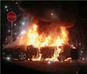  ?? — AP ?? A car burns after petrol bombs were thrown at police in Creggan, Londonderr­y.