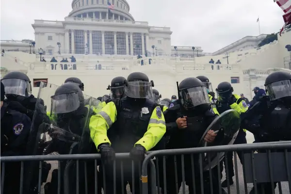  ?? Kent Nishimura/Los Angeles Times/TNS ?? above: Police try to hold back protesters Wednesday who gathered to storm the Capitol and halt a joint session of the 117th Congress in Washington, D.C.