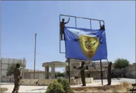 ??  ?? In this file photo released in 2016by Hawar news, the news agency for the semiautono­mous Kurdish areas in Syria (ANHA), shows Kurdish-led Syria Democratic Forces raising their flag after driving Islamic State militants out of the area, in Manbij, Syria.
