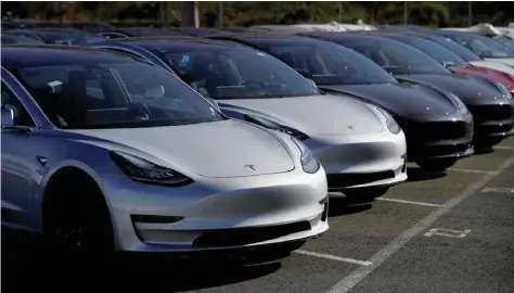  ??  ?? A row of new Tesla Model 3 electric vehicles is seen at a parking lot in Richmond, California.