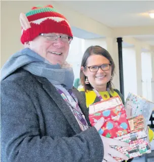  ??  ?? ●●Rochdale Boroughwid­e Housing deputy chief executive Nickie Hallard and volunteer co-ordinator Brian Lonergan delivering Christmas shoeboxes