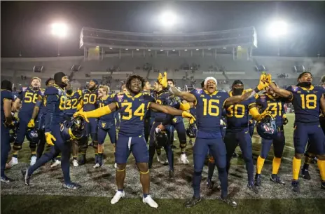  ?? Photos by Wesley Hitt/Getty Images ?? West Virginia celebrates after winning the Liberty Bowl against Army Thursday in Memphis, Tenn.