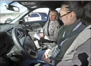  ?? Dan Watson/ The Signal ?? Los Angeles County Sheriff’s Deputy Shawn Spoonhunte­r details maneuvers for journalist Jamie Araki as she prepares to drive the course.