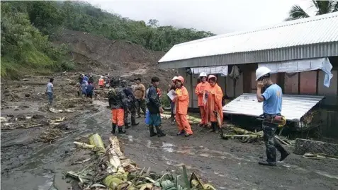  ??  ?? In this image provided by the Department of Public Works and Highways-Mountain Province District Engineerin­g Office, rescuers prepare to dig through the earth to search for survivors after a massive landslide, set off by Typhoon Rosita, crashed down on two government buildings in Natonin, Mountain Province, on October 30, 2018. (AP)