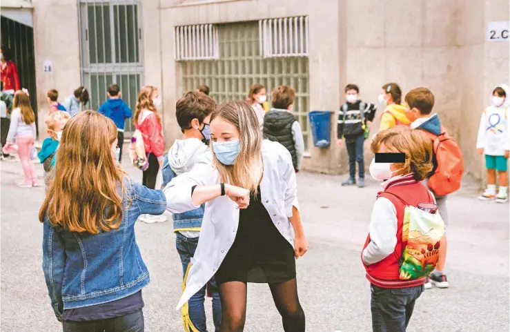  ?? JON RODRIGUEZ BILBAO/EFE ?? Alumnos se saludan con los codos, una forma de interactua­r que nos ha dejado la covid-19