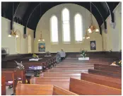  ?? 01_B16church0­6_pews_flowers_church ?? Visitors walk down the pews and look at the floral displays.