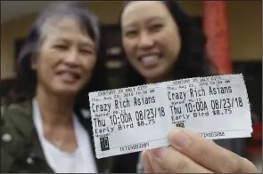  ?? AP Photo/Jeff Chiu) ?? In this Thursday, Aug. 23, photo, Audrey Sue-Matsumoto, right, holds tickets as she poses for photos with her mother Alice Sue while interviewe­d outside of a movie theater after watching the movie Crazy Rich Asians in Daly City, Calif. It was Alice Sue’s second time watching the movie. When “Crazy Rich Asians” surpassed expectatio­ns and grabbed the top spot in its opening weekend, the film also pulled off another surprising feat. It put Asians of a certain age in theater seats.