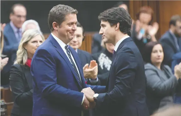  ?? ADRIAN WYLD / THE CANADIAN PRESS ?? Prime Minister Justin Trudeau shakes hands with Andrew Scheer in the House of Commons Thursday, after he announced he was stepping down as leader of the Conservati­ves.