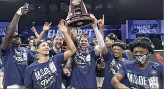  ?? Jamie Squire / Getty Images ?? The Bulldogs celebrate with the West Regional Champion trophy after defeating the Trojans in the Elite Eight. Gonzaga will be the third team to bring an undefeated record into the Final Four since the bracket expanded to 64 teams in 1985. They will face either UCLA or Michigan on Saturday night.