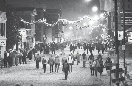  ?? THE ASSOCIATED PRESS ?? Visitors at the 1980 Winter Olympics stroll through the snow-covered downtown area of Lake Placid, N.Y.