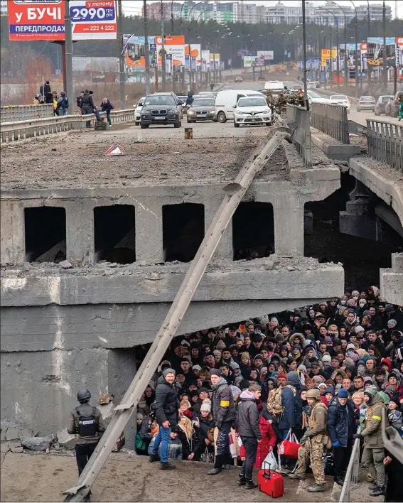  ?? ?? SHELTER: Desperate families gather under the remains of a bridge in the town of Irpin. It was blown up by Ukrainian troops to slow the Russian advance