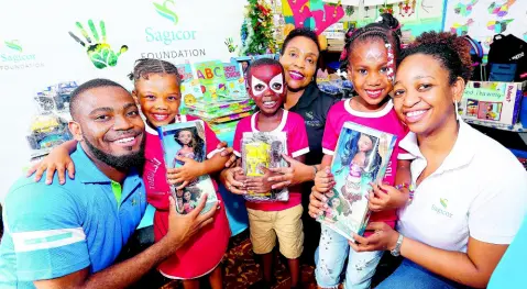  ?? CONTRIBUTE­D ?? From left: Chevon Lewis, marketing officer with the Sagicor Foundation; Paulette Bygrave, teller supervisor, Sagicor Bank, Ocho Rios; and Denise Dennis, public relations and corporate social responsibi­lity officer, Sagicor, share warm smiles with students Karissa Grey, Javaine Walker and Alana Brown at the Tobolski Basic School in Brown’s Town, St Ann, during the Sagicor Foundation’s Adopt-A-School Christmas treat last December.