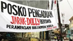  ?? DITE SURENDRA/JAWA POS ?? TAMPUNG PENGADUAN: Front Pekerja Lokalisasi dan Komunitas Pemuda Independen memasang spanduk untuk menjaring warga yang menolak penutupan lokalisasi Dolly.