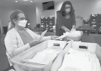  ?? SETH WENIG/AP ?? Ann Carlette, left, processes mail-in ballots Wednesday for Bergen County in Hackensack, New Jersey.