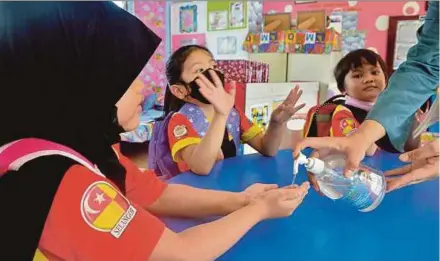  ?? PIC BY FAIZ ANUAR ?? Children at a kindergart­en in Klang sanitising their hands following the rise of hand, foot and mouth disease cases in the country.