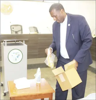  ?? Katie West • Times-Herald ?? Forrest City Mayor Cedric Williams unpacks one of the 1,000 PPE (personal protection equipment) kits donated to Forrest City by the Arkansas Black Mayors Associatio­n. The kits will be distribute­d on Friday to facilities such as churches, daycares and elderly groups.