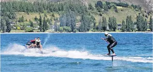  ?? PHOTO: KERRIE WATERWORTH ?? Riding high . . . Kelly Gooch demonstrat­es the newly available activity of foil surfing on Lake Wanaka yesterday.