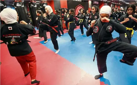  ?? — Photos: AFP ?? Kuwaiti women practise hybrid martial art Kajukenbo in a club in Kuwait City.