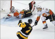  ?? Gene J. Puskar ?? The Associated Press Penguins defenseman Justin Schultz follows through on his winning shot against Flames goalie Jon Gillies and center Mikael Backlund in overtime of Pittsburgh’s 4-3 victory Monday at PPG Paints Arena.