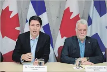  ?? JACQUES BOISSINOT THE CANADIAN PRESS ?? Prime Minister Justin Trudeau, with Quebec Premier Philippe Couillard, speaks at a roundtable meeting with members of the aluminum industry in Saguenay, Que. Monday.