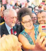  ??  ?? > Jeremy Corbyn poses for a selfie during campaignin­g in Watford yesterday