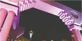  ??  ?? The Calgary Tower is framed by the colourful arches at Olympic Plaza.