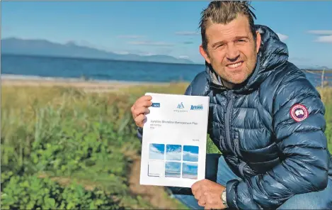  ??  ?? Councillor Jim Montgomeri­e with the Ayrshire Shoreline Management Plan and the northern hills of Arran in the background.