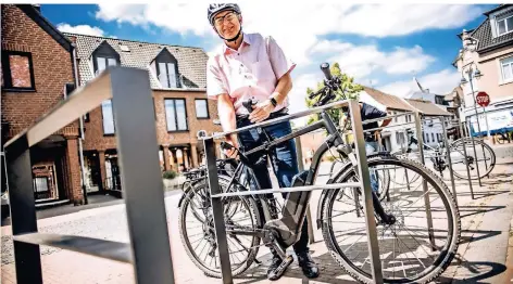  ?? RP-FOTO: ANDREAS ENDERMANN ?? Technische­r Beigeordne­ter Michael Assenmache­r kettet sein Rad an einem der neuen Bügel im Zentrum von Osterath an.