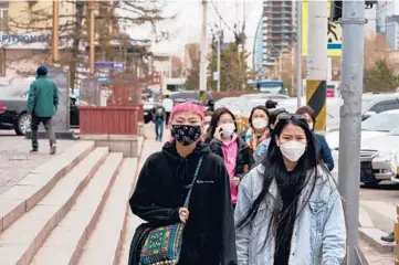  ?? KHASAR SANDAG/THE NEW YORK TIMES ?? Pedestrian­s in Ulaanbaata­r, Mongolia on May 12. Chinese-made vaccines had Mongolia promising its citizens a “COVID-free summer.” However, on June 20, the country recorded 2,400 new infections.