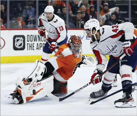  ?? MATT SLOCUM — THE ASSOCIATED PRESS ?? Philadelph­ia Flyers’ Carter Hart blocks a shot by Washington Capitals’ Tom Wilson, right, during the third period Wednesday night in Philadelph­ia. Washington won, 2-1, in a shootout.