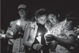  ?? Mark Ralston / AFP / Getty Images ?? People gather to pray during a candleligh­t vigil in El Paso for victims of a shooting that left a total of 22 people dead at the Cielo Vista Mall Walmart.
