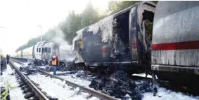  ??  ?? Officials are seen near the German high-speed train that caught fire.