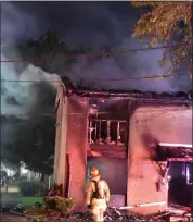  ?? PHOTOS COURTESY DANIEL JASINA ?? A firefighte­r stands near a townhome where Wednesday morning’s fire is believed to have started in a kitchen area.