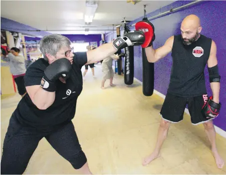  ??  ?? Jillian Carson, left, spars with boxing instructor Jason Heit at Victoria Mixed Martial Arts.