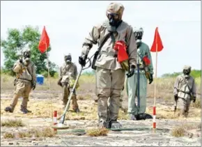  ?? RICHARD NYBERG/USAID/AFP ?? Soldiers in protective gear at a presentati­on on detecting unexploded ordnance and defoliant Agent Orange during the launch of a US-funded project to clean up Agent Orange contaminat­ion at the Vietnamese city of Danang in 2011.