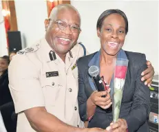  ?? CONTRIBUTE­D PHOTOS ?? Acting Deputy Commission­er of Police Dr Gary Welsh, presents Nadine McFarlane Stewart from the Ministry of Health with a rose.