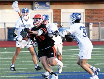  ?? DREW ELLIS — FOR MEDIANEWS GROUP ?? Brother Rice’s Will Babinchak, middle, attempts to clear the ball through three Detroit Catholic Central defenders during Tuesday’s CHSL lacrosse match. The Warriors won 16-10.